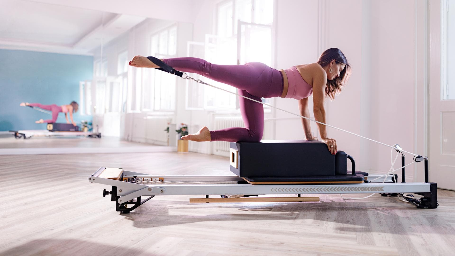 Frau trainiert mit Pilates Reformer