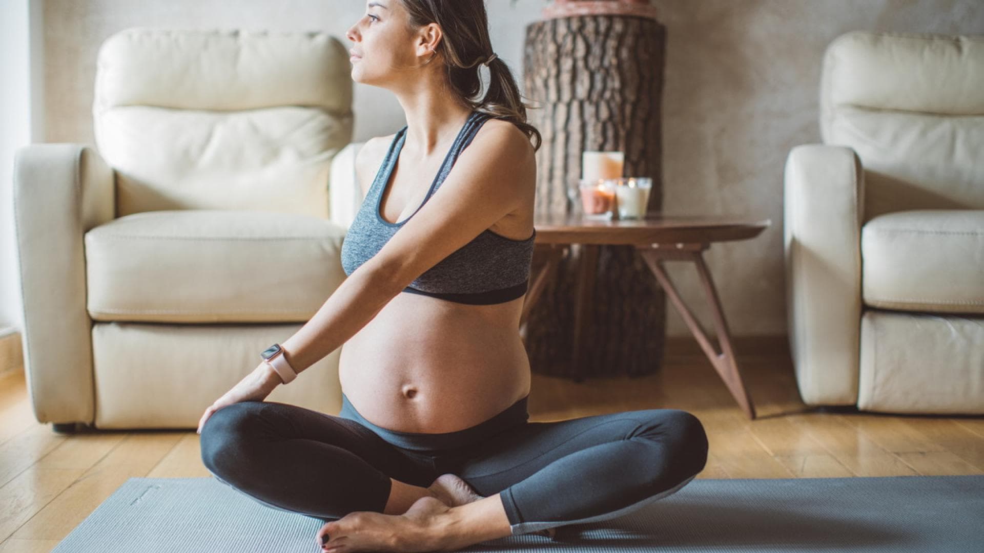 Schwangere Frau auf Fitnessmatte