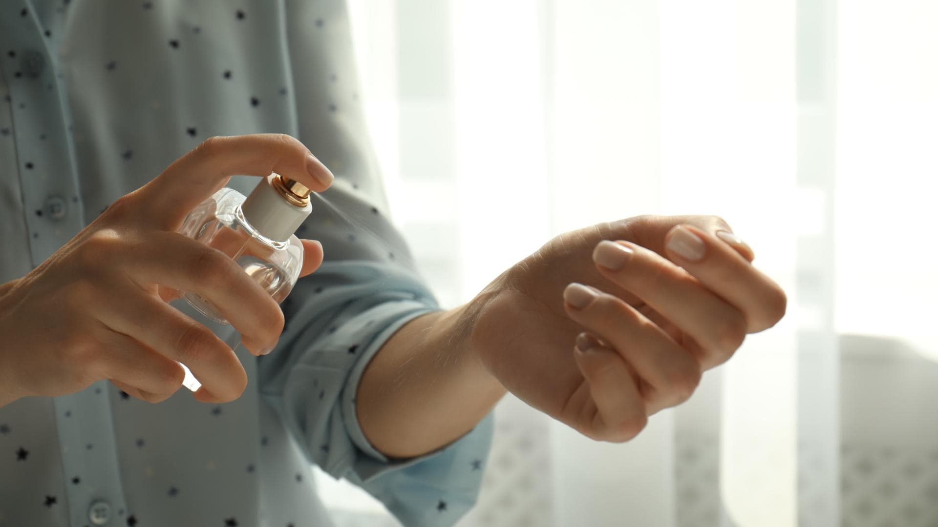 Mit diesen Tipps können Sie ganz einfach Ihr eigenes natürliches Bodyspray selber machen. Frau sprüht Bodyspray auf das Handgelenk