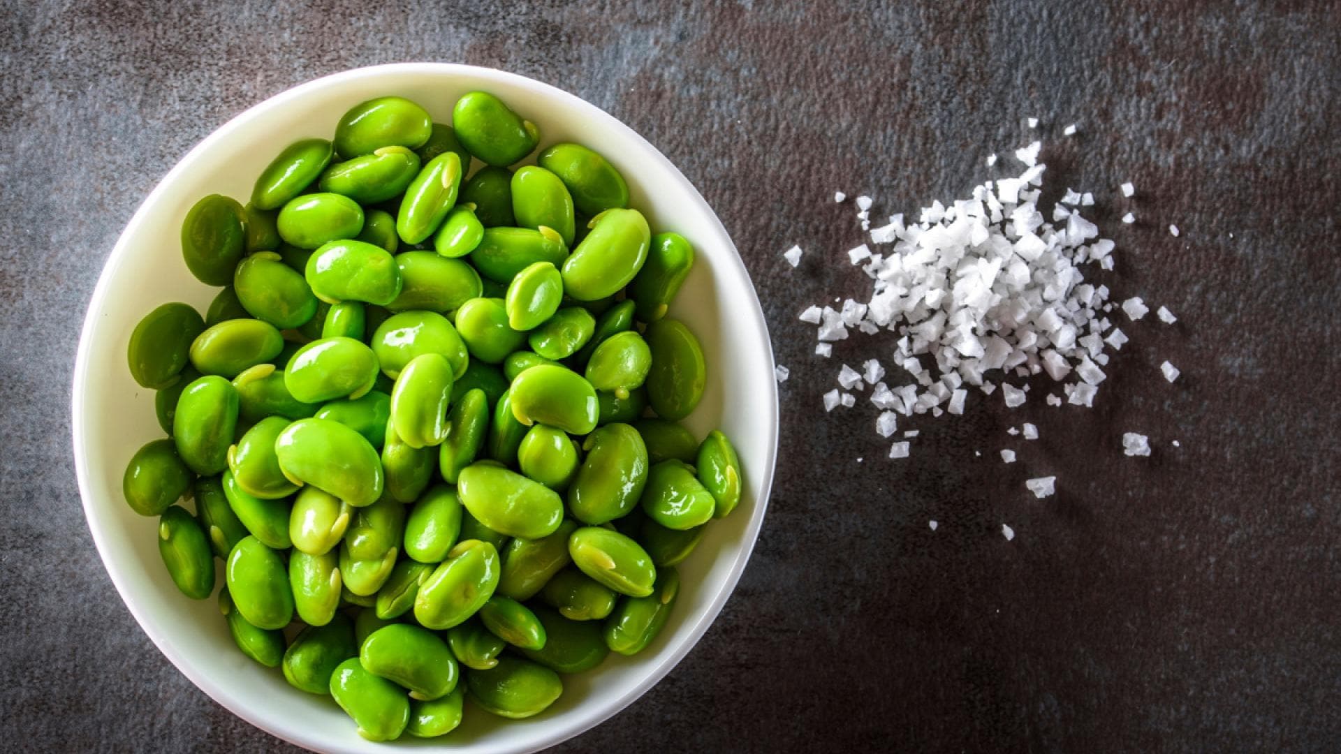 Edamame in einer Schale mit Salz auf einer Schieferplatte