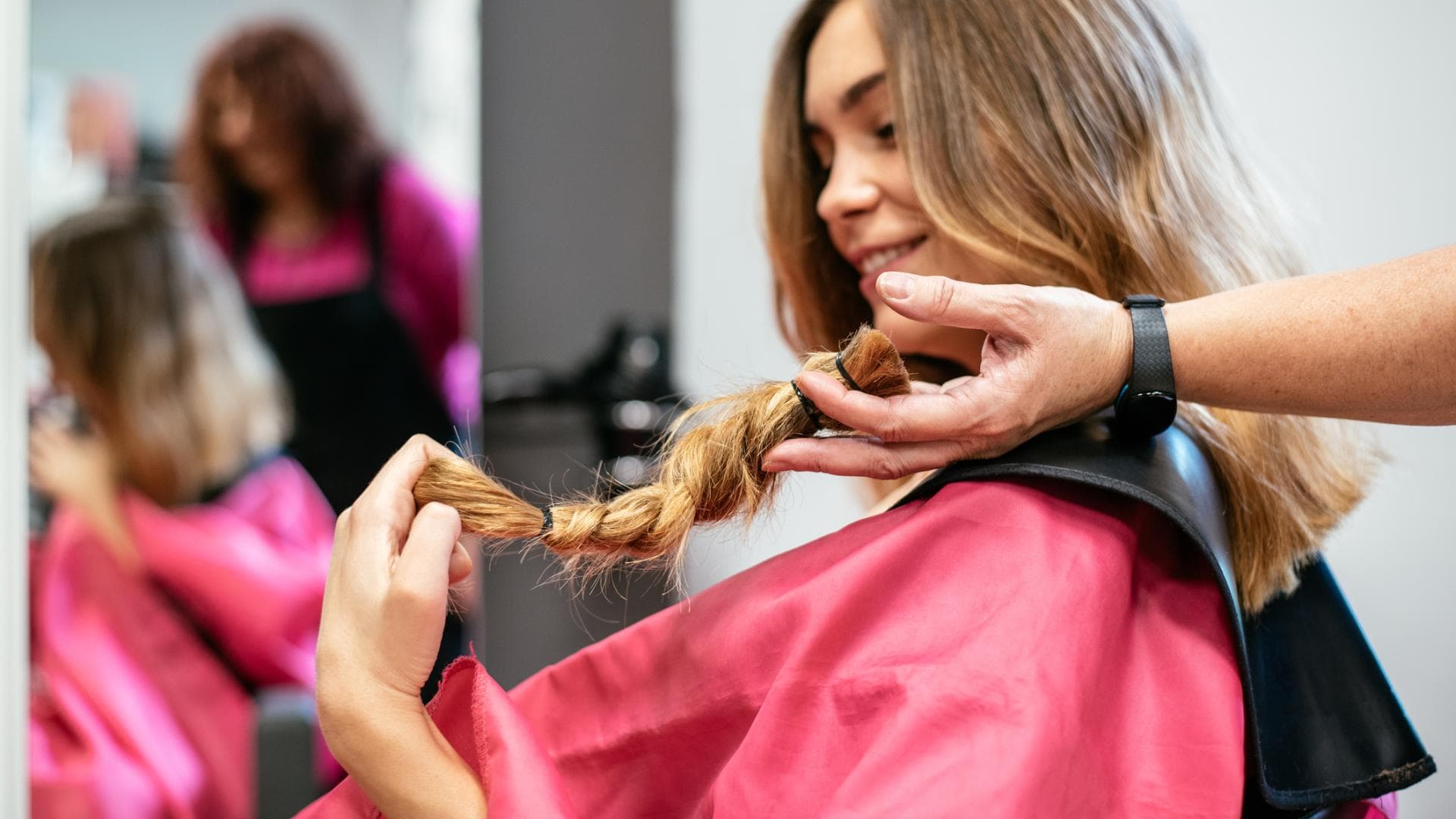 Frau sitzt beim Friseur, um ihre Haare zu spenden Frau sitzt beim Friseur, um ihre Haare zu spenden