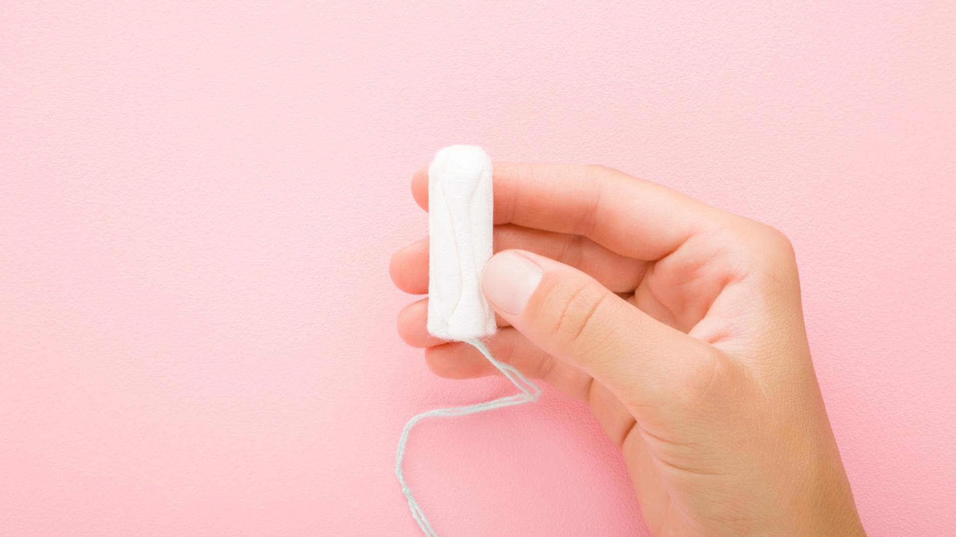 Frau hält Tampon in der Hand