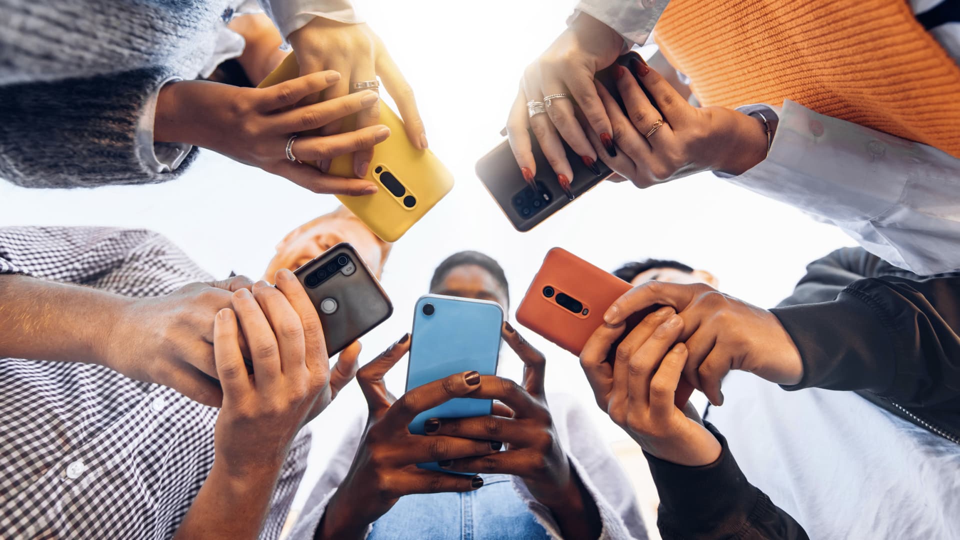 Nomophobie ist die Angst, ohne Mobiltelefon zu sein. Eine Gruppe Menschen, die alle ein Handy in der Hand halten