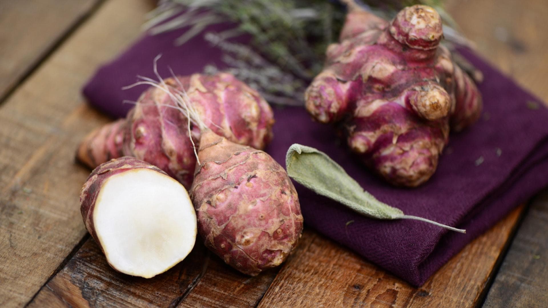 So gesund ist Topinambur Aufgeschnittene Topinambur auf einem Holztisch