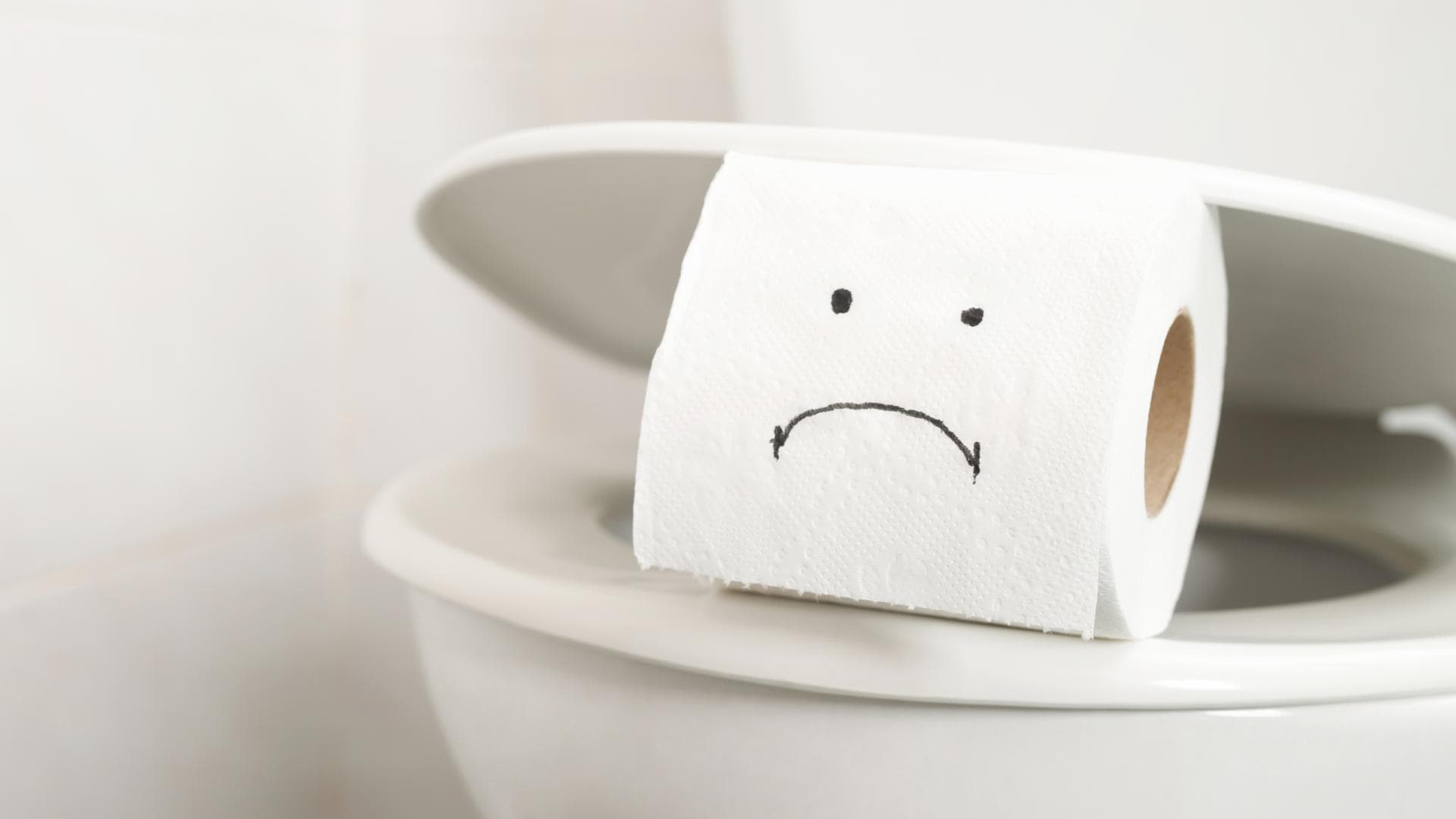 Rolle Toilettenpapier mit einem traurigen Gesicht drauf