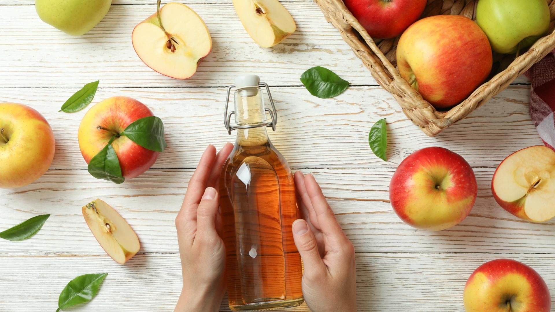 Frau hält Flasche mit Apfelessig in den Händen Frau hält Flasche mit Apfelessig in den Händen