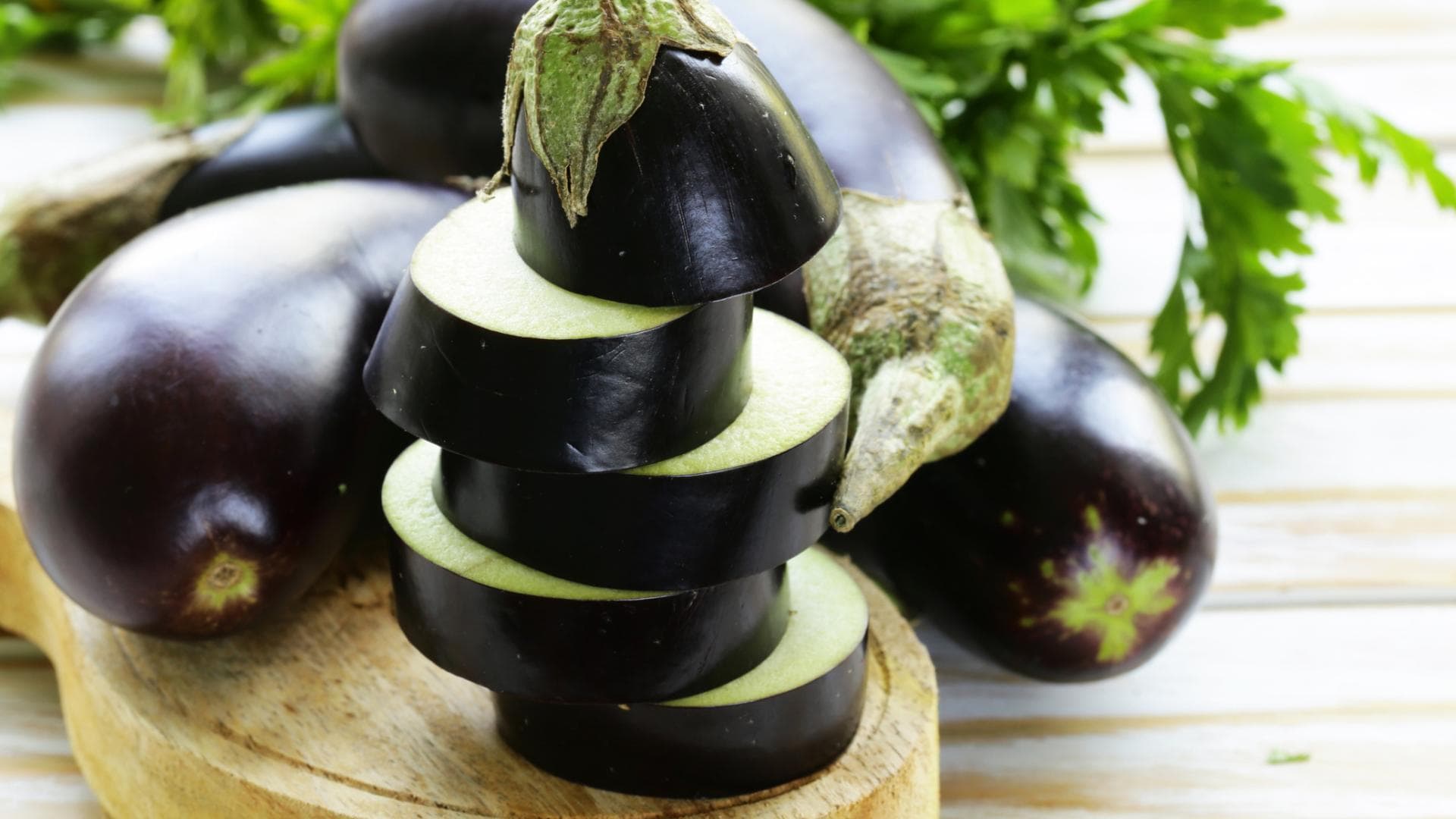 Aufgeschnittene Aubergine auf einem Brett Aufgeschnittene Aubergine auf einem Brett