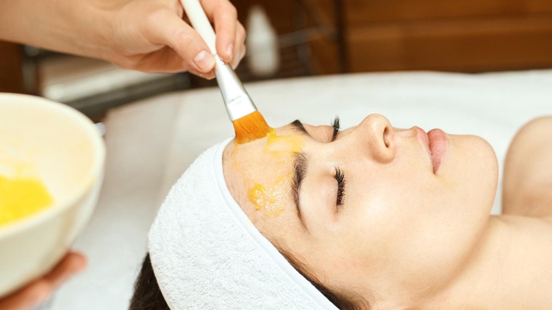 Frau bekommt ein Peeling auf das Gesicht aufgetragen Frau bekommt ein Peeling auf das Gesicht aufgetragen