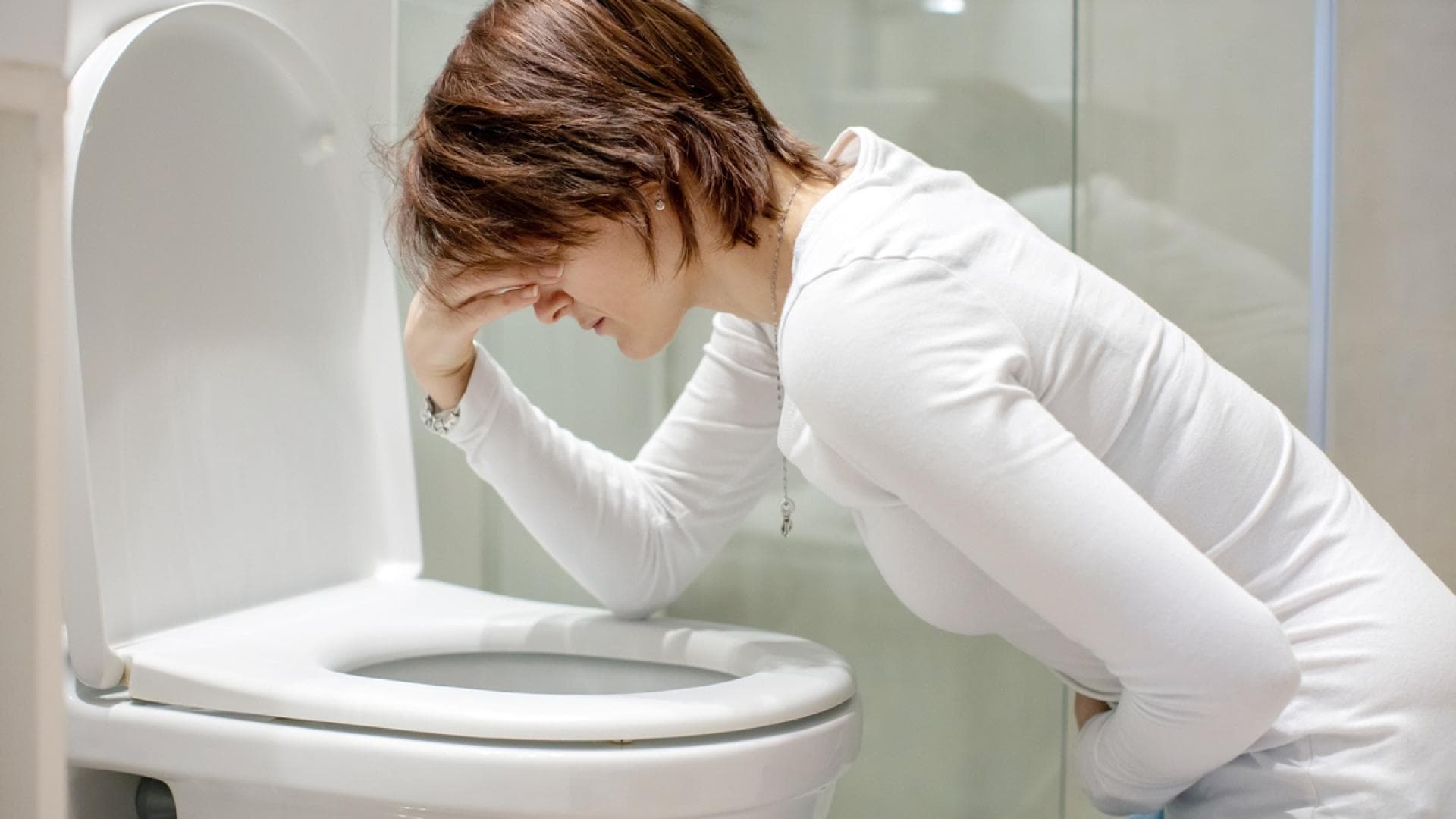 Frau muss sich über Toilette übergeben Frau muss sich über Toilette übergeben