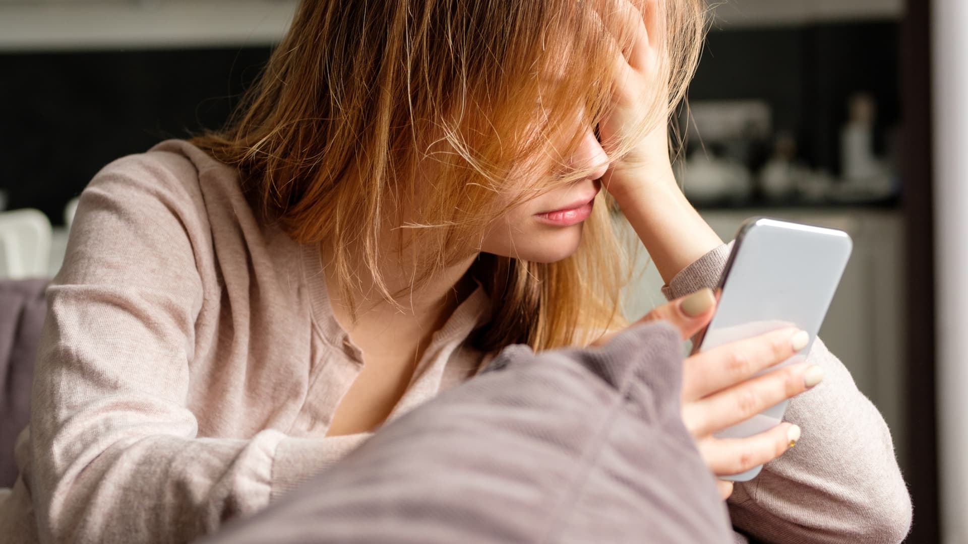 Frau schaut traurig auf Ihr Handy