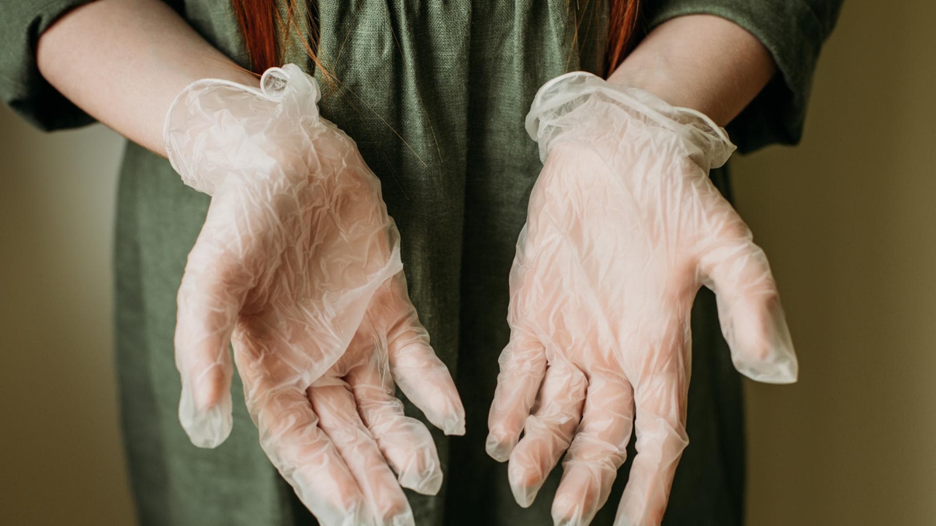 Ärztin hält in Latexhandschuhe verpackte Hände mit den Handflächen nach vorn in die Kamera