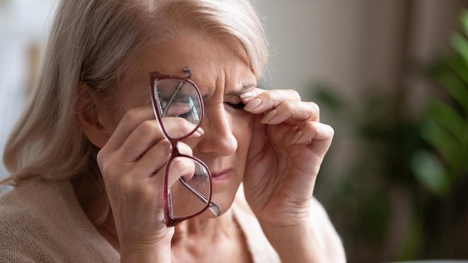 Frau reibt sich aufgrund von Beschwerden über die Augen Frau reibt sich aufgrund von Beschwerden über die Augen