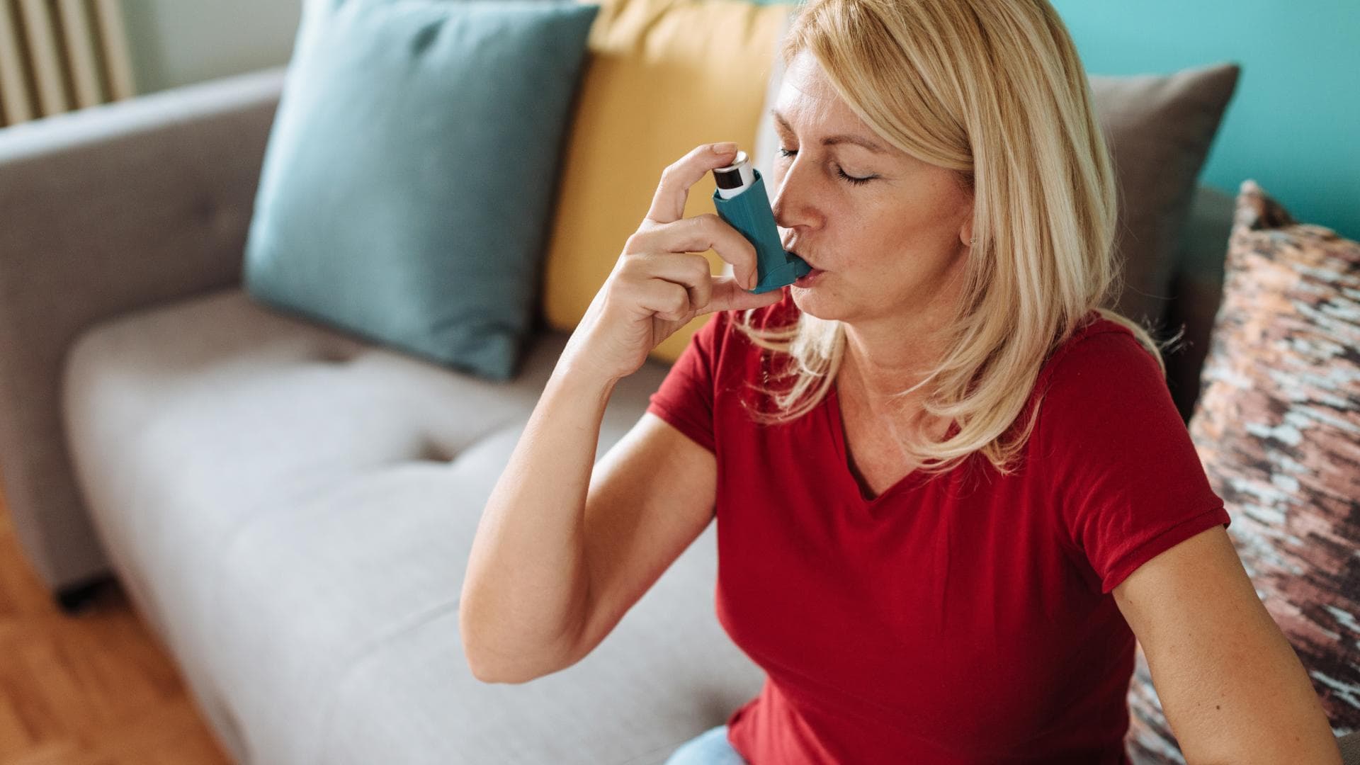 Frau hat allergisches Asthma und nutzt einen Inhalator. Frau hat allergisches Asthma und nutzt einen Inhalator.