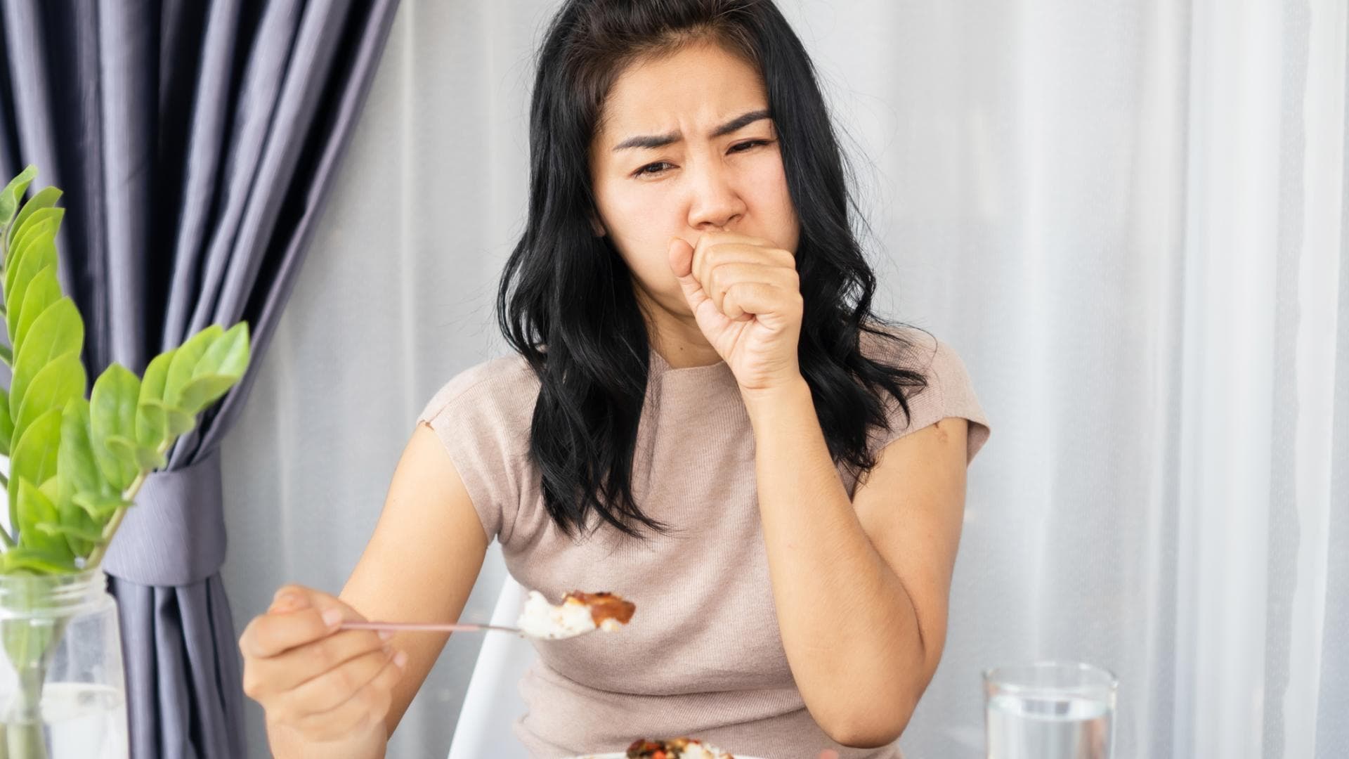 Frau verschluckt sich beim Essen Frau verschluckt sich beim Essen