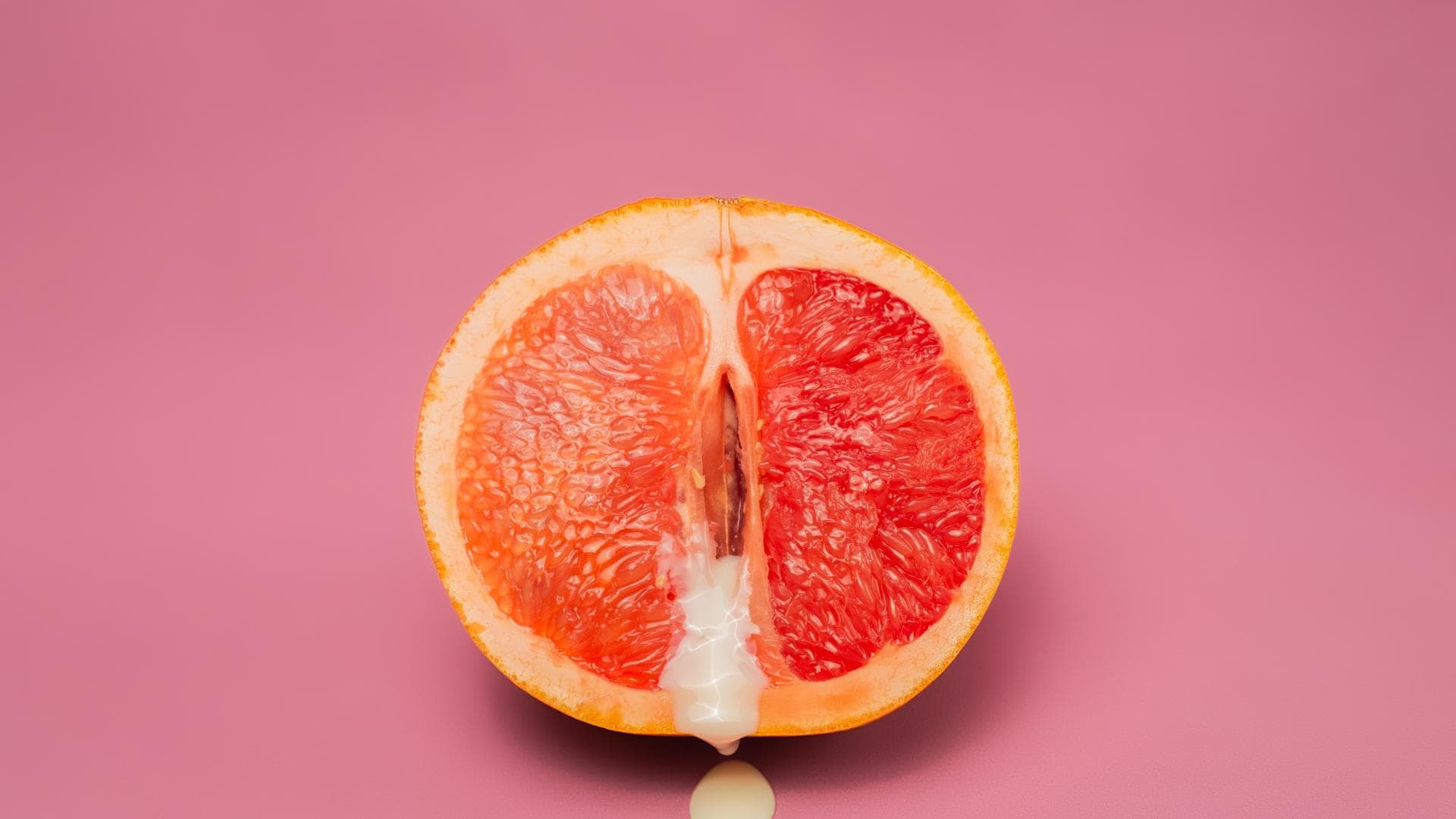 Grapefruit, aus der Vanillepudding herausläuft Grapefruit, aus der Vanillepudding herausläuft