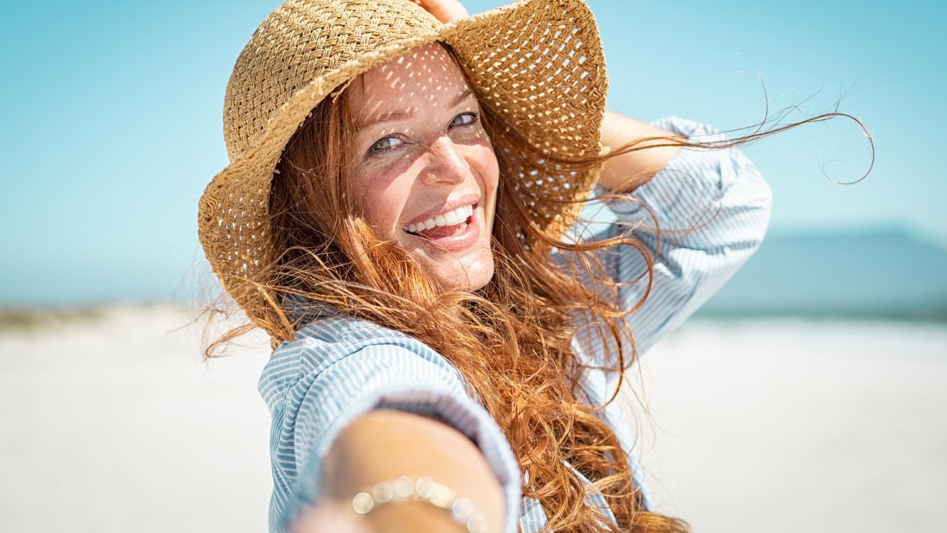 Frau mit Sonnenhut am Strand Frau mit Sonnenhut am Strand