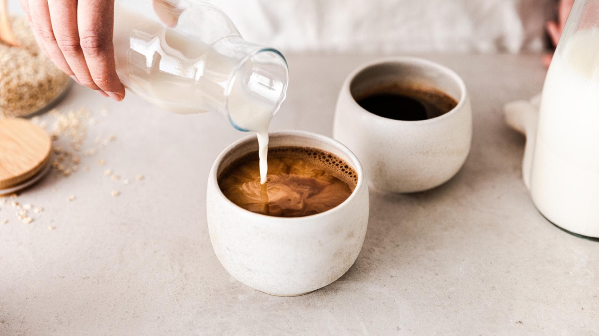 Frau gibt Milch in Kaffee Frau gibt Milch in Kaffee