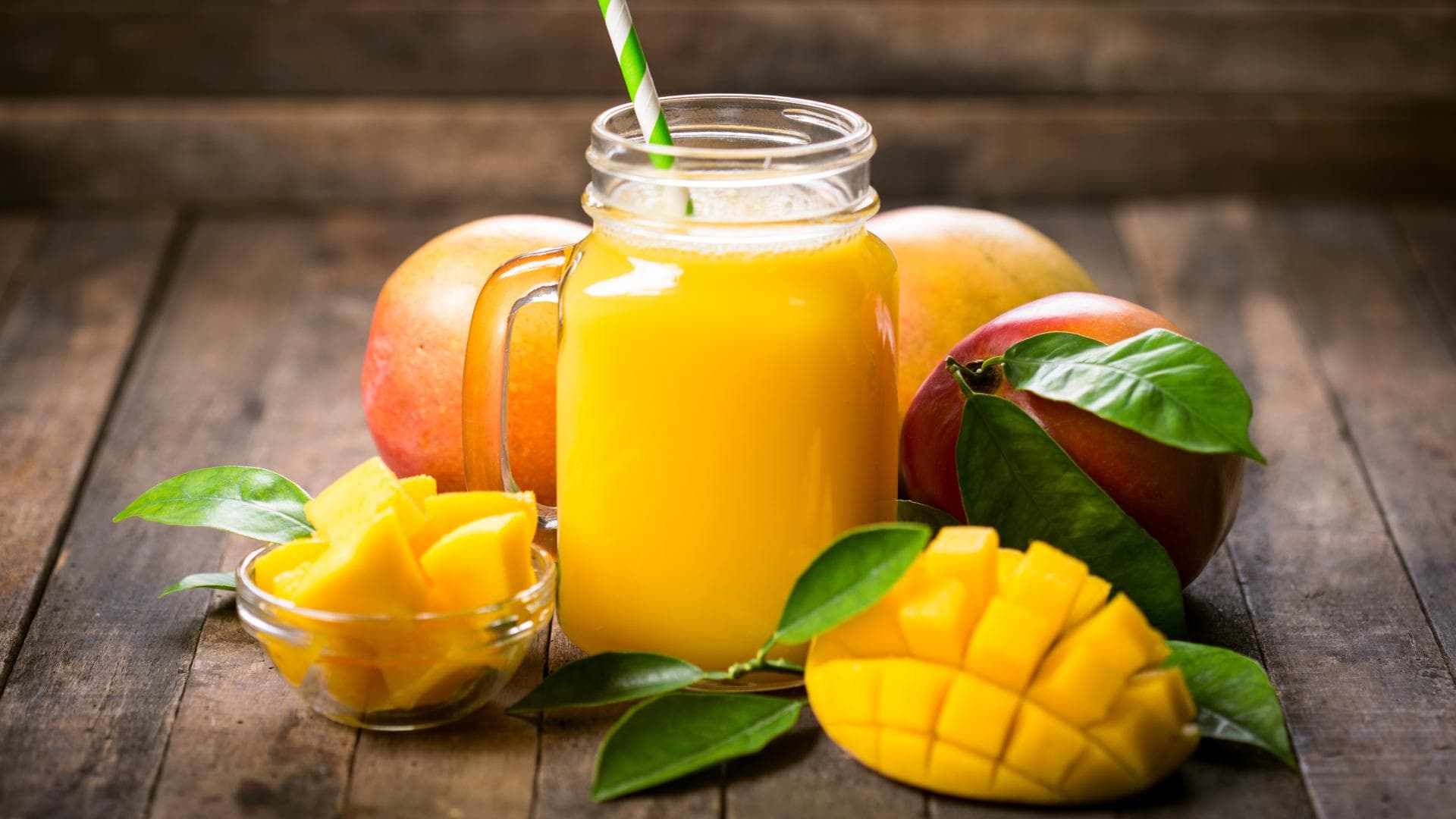 Ein Glas Mangosaft umgeben von Mangofrüchten Ein Glas Mangosaft umgeben von Mangofrüchten.