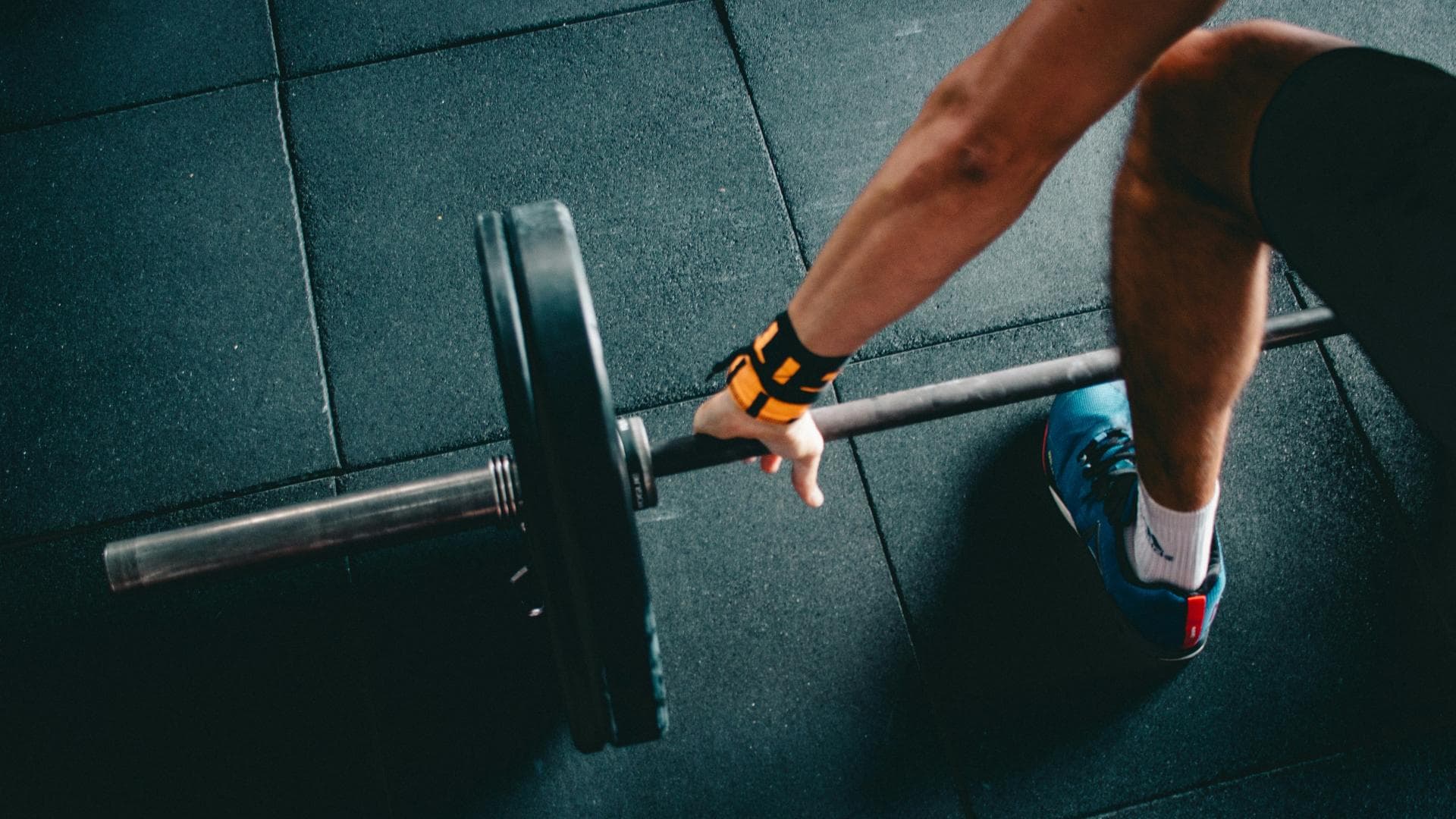 Mann im Fitnessstudio mit Hantelstange
