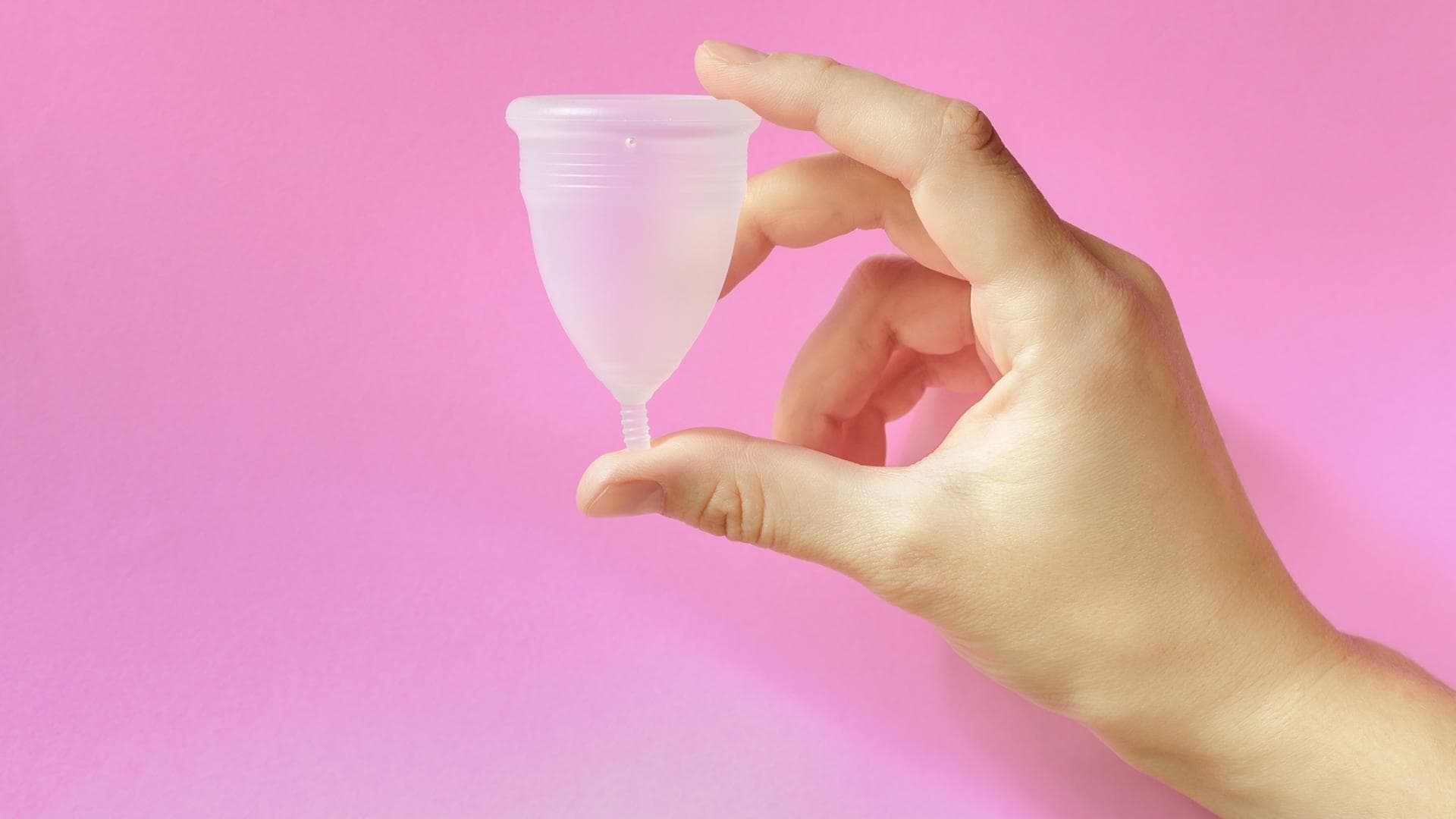 Frau hält Menstruationstasse in der Hand Frau hält Menstruationstasse in der Hand