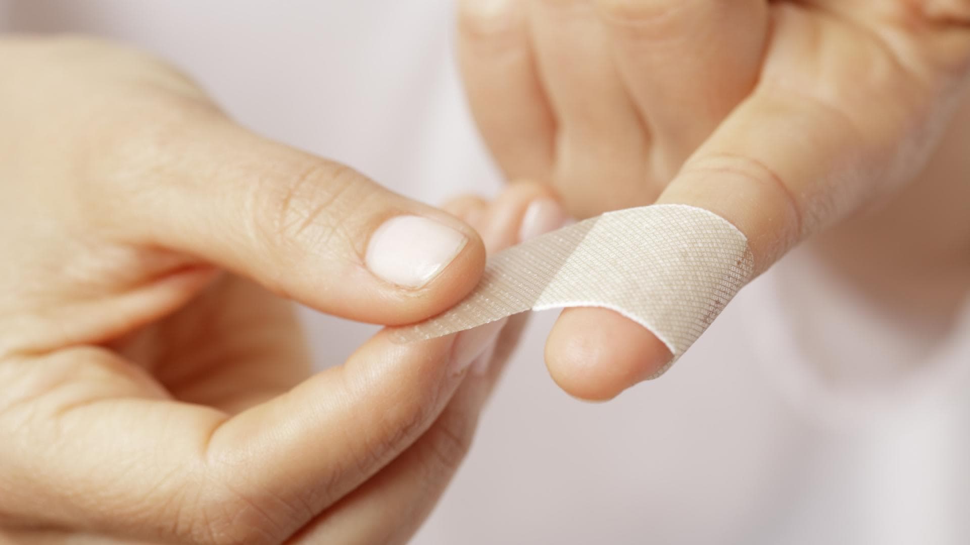 Pflaster wird auf Finger geklebt