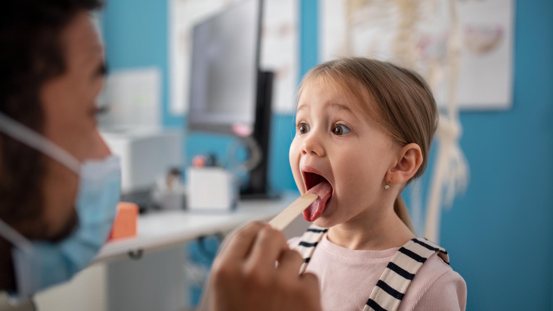 Kinderarzt schaut einem Mädchen in den Rachen. Kinderarzt schaut einem Mädchen in den Rachen.
