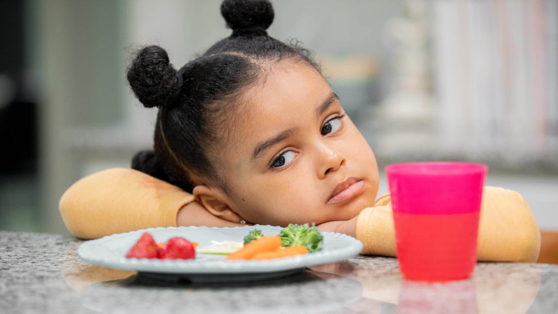 Selektive Essstörung bei Kindern scheint tatsächlich häufig vorzukommen Kind guckt Teller mit Gemüse sehr skeptisch an