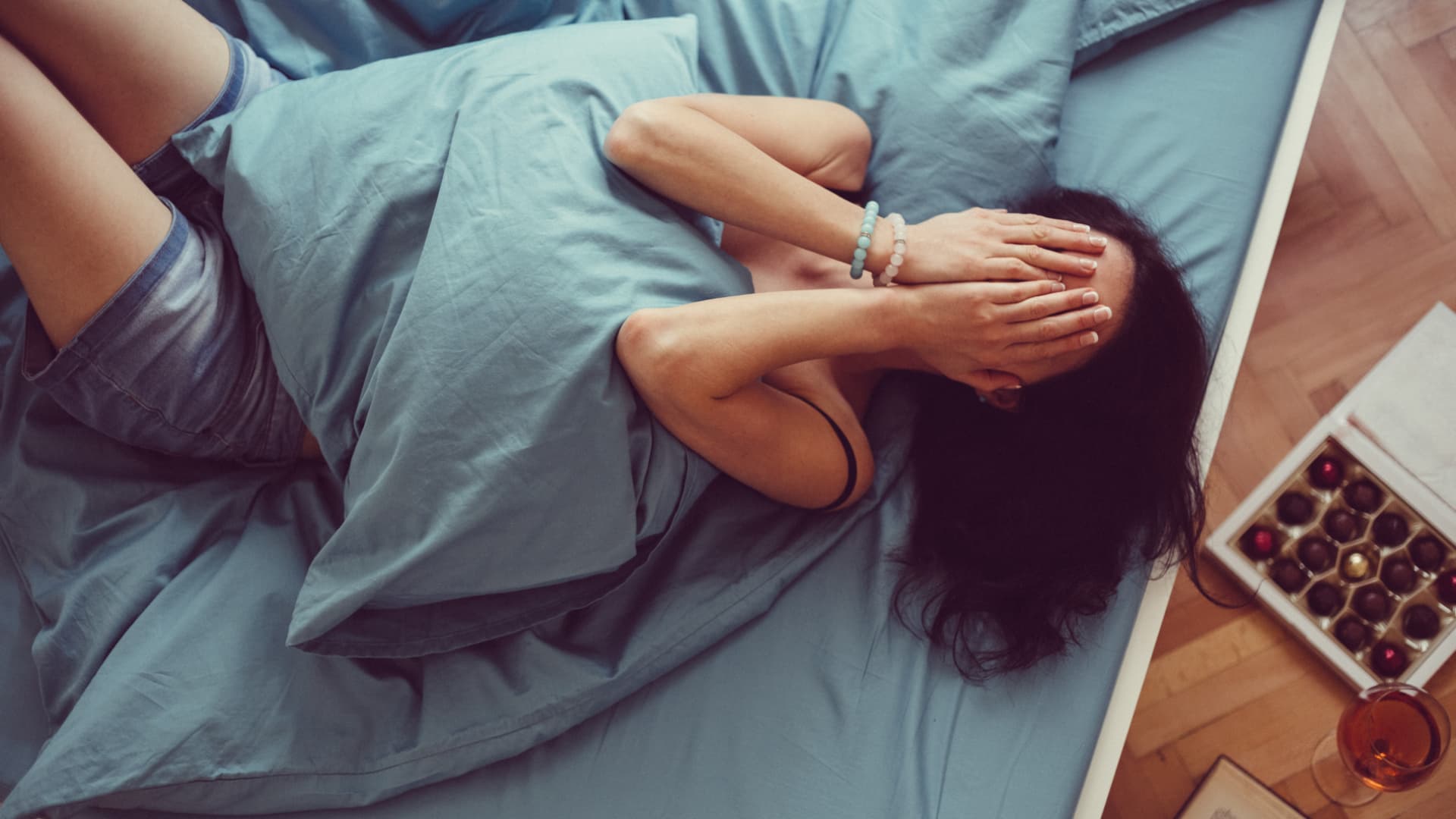 Eine unerwiderte Liebe kann quälend und belastend sein. Frau liegt im Bett und weint