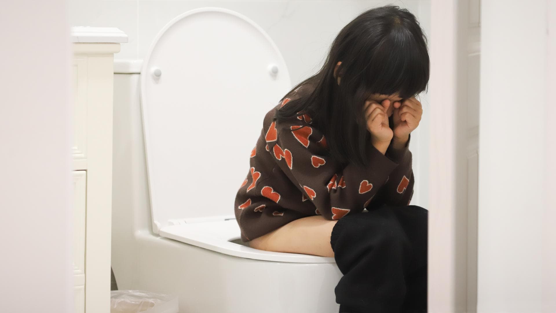Kind sitzt mit Verstopfung auf Toilette. Verstopfung bei Kindern Lösen: Kind sitzt mit Verstopfung auf Toilette.