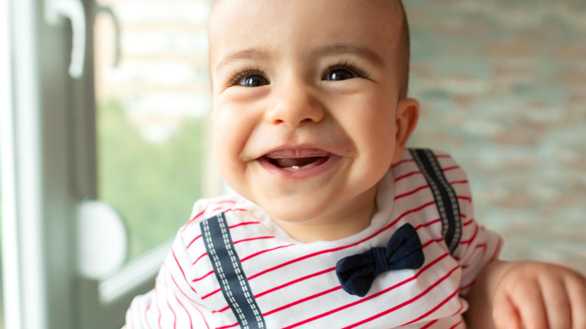 Baby mit frischem Zahn lacht in die Kamera. Baby mit frischem Zahn lacht in die Kamera.