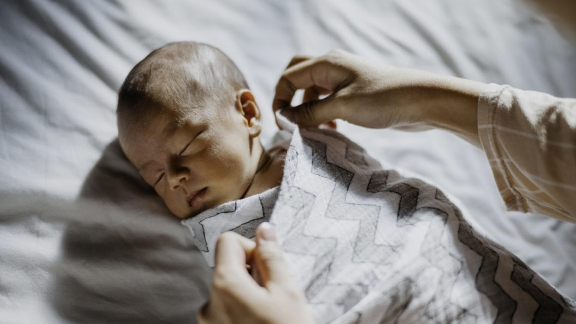 Baby pucken zum Einschlafen Baby wird in eine Decke eingewickelt