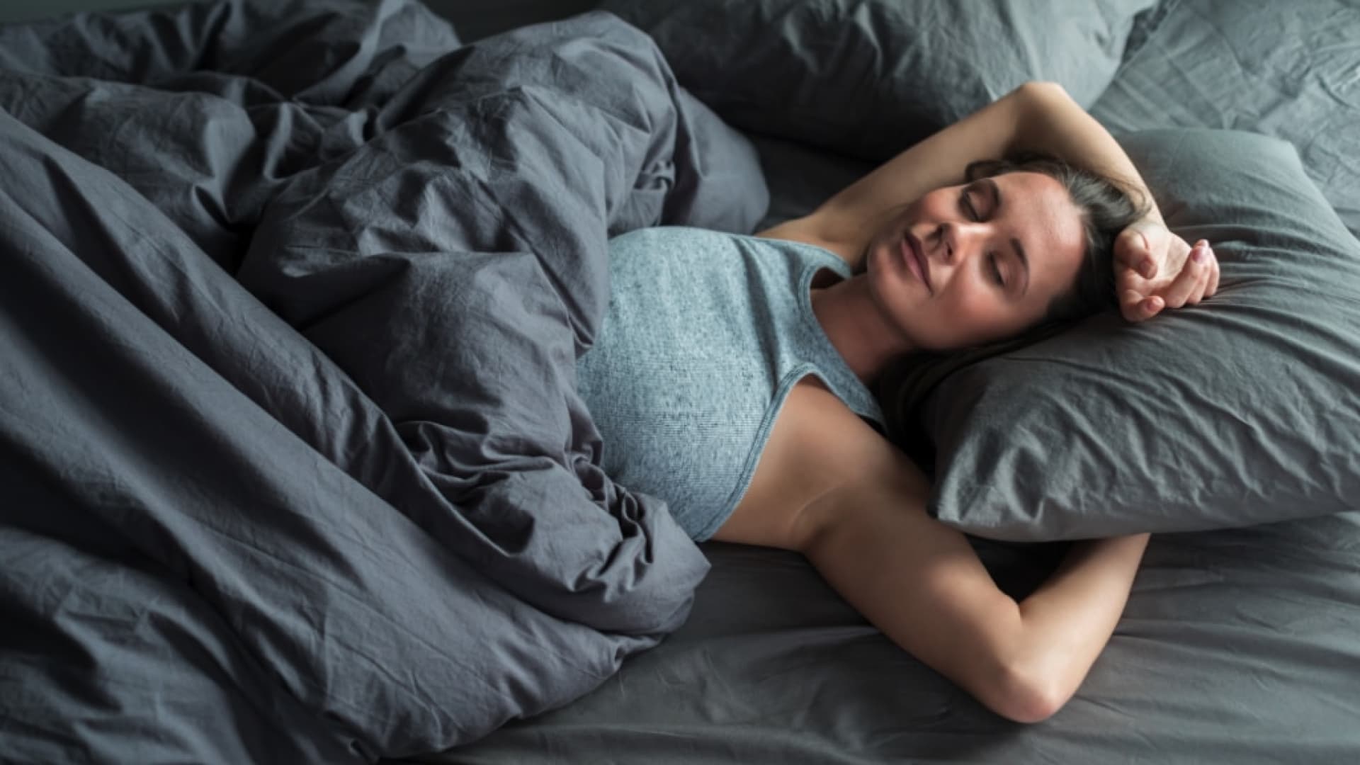 Junge Frau liegt im Bett und schläft.