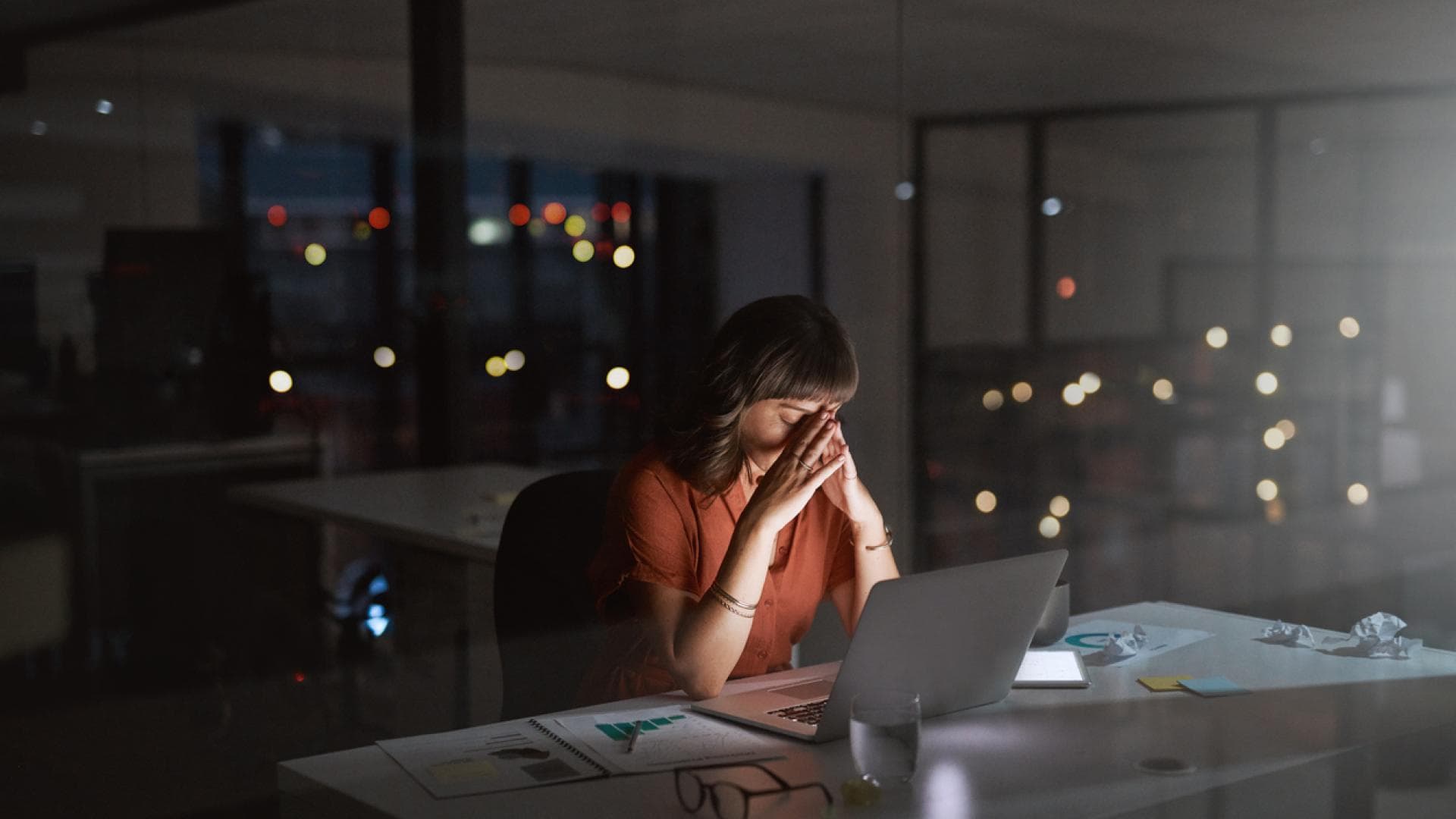 Wenn zu viel Arbeit krank macht Überarbeitete Frau sitzt spät am Abend im leeren Büro