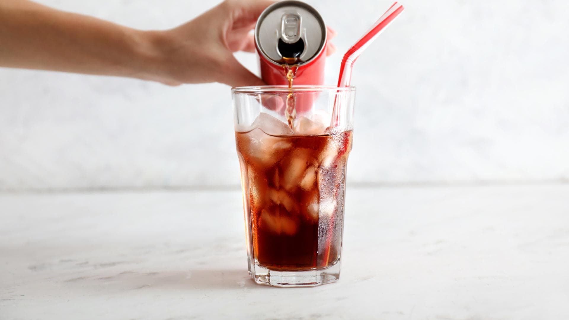 Cola wird in ein Glas eingegossen Cola wird in ein Glas eingegossen