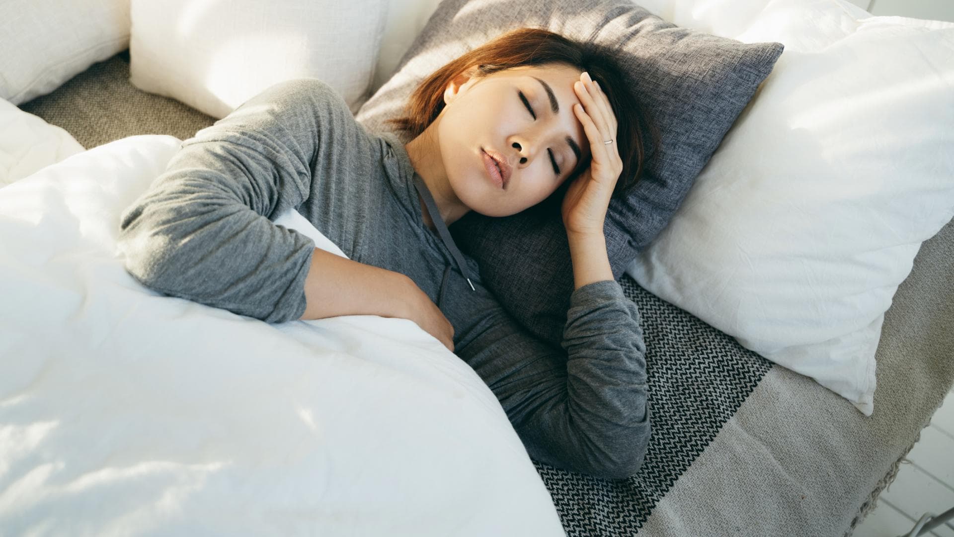Frau liegt mit Schwindel im Bett Frau liegt mit Schwindel im Bett