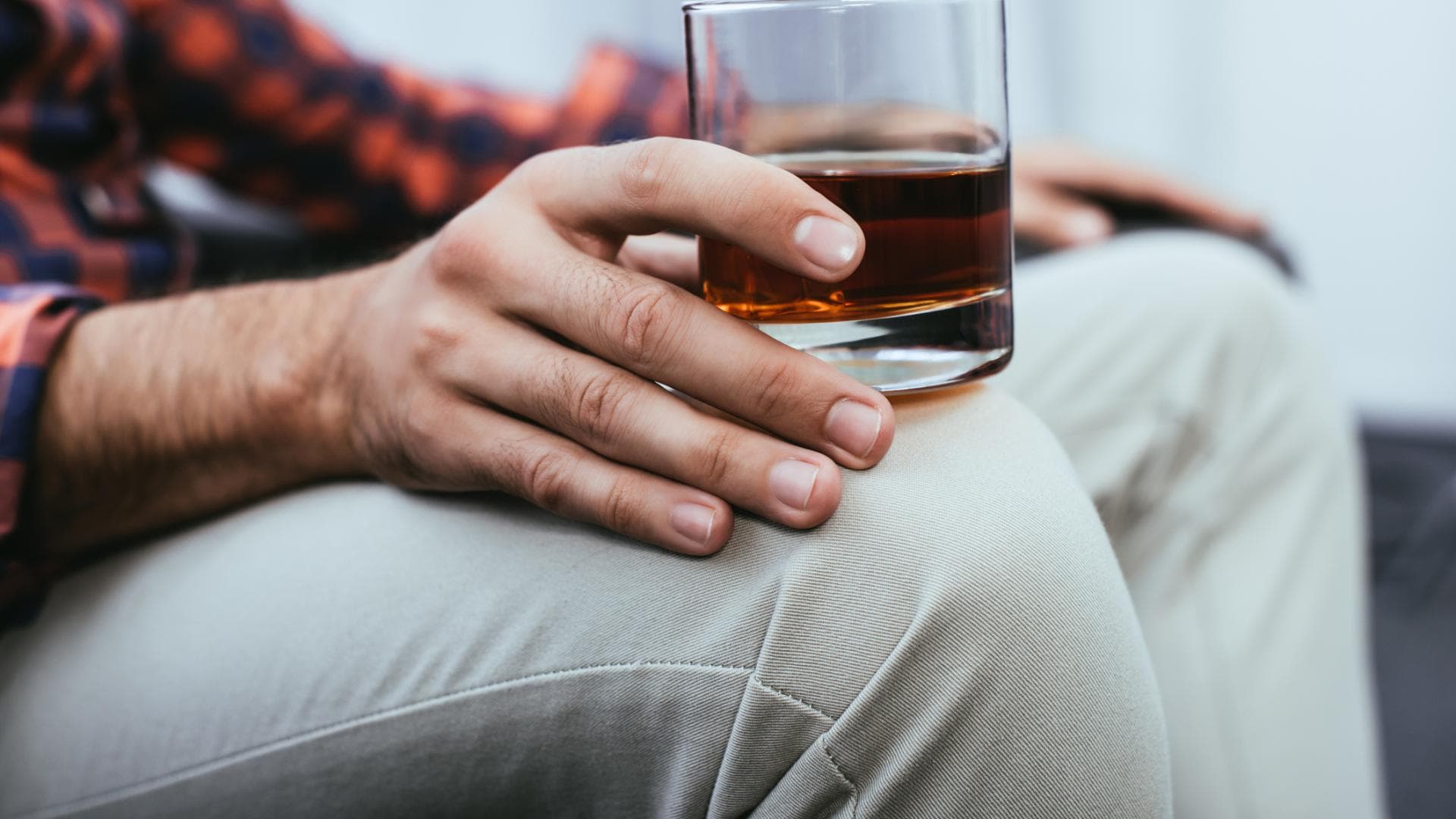 Männerhände mit einem Glas Whiskey in der Hand Männerhände mit einem Glas Whiskey in der Hand