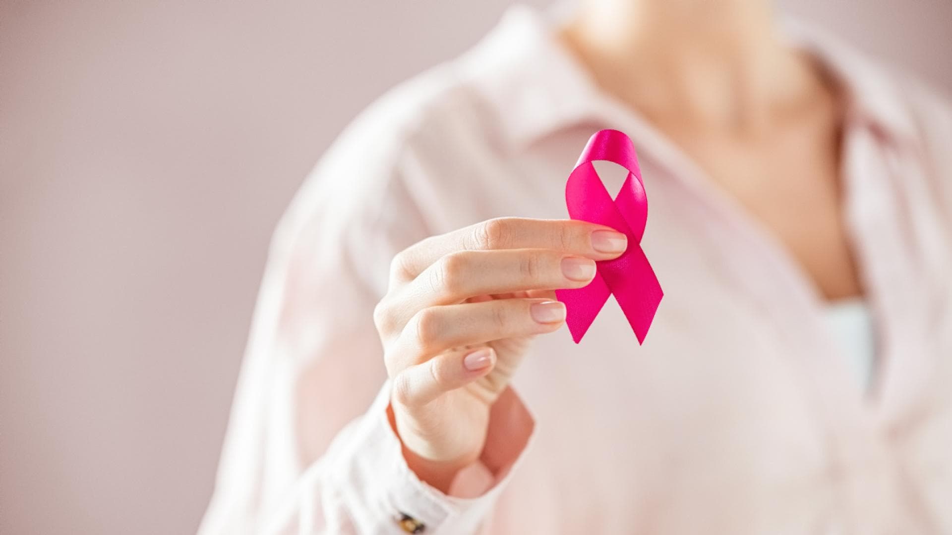 Frau hält pinke Schleife in den Händen Frau hält pinke Schleifen in den Händen