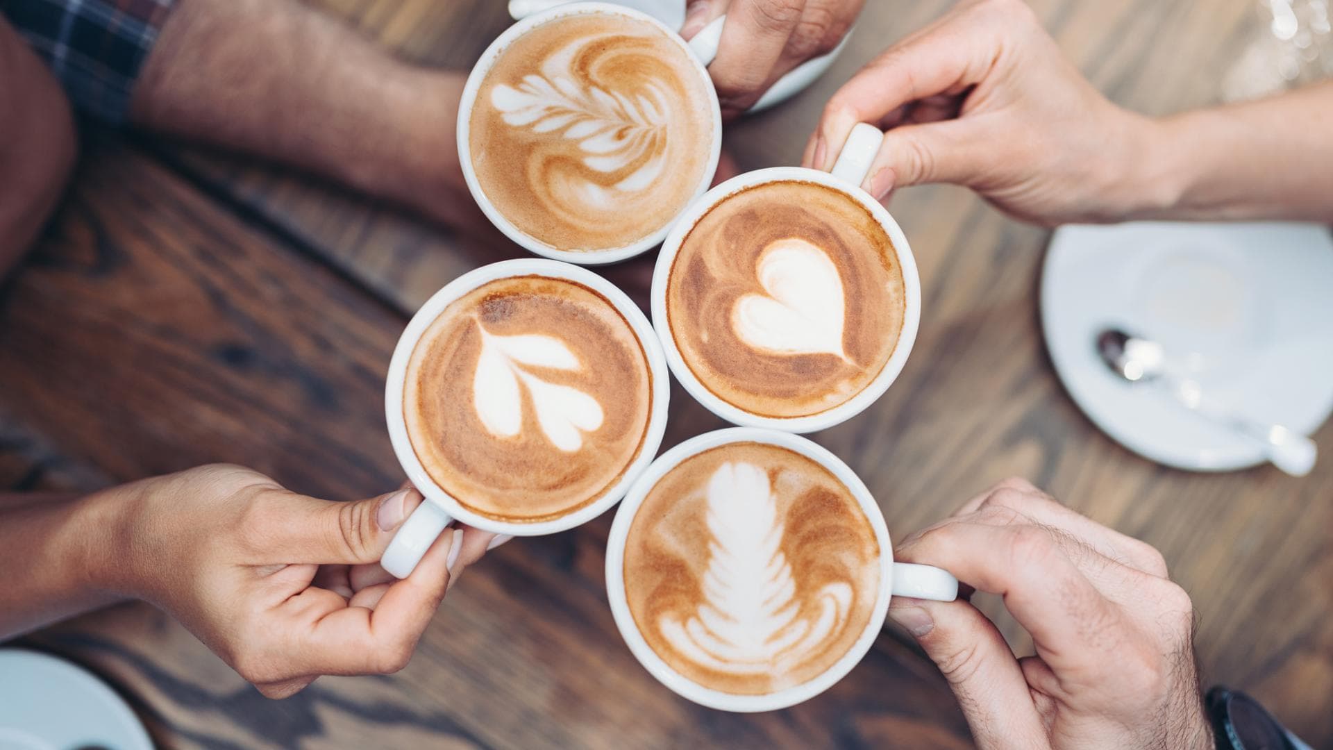 Hände, die mit Kaffee anstoßen Hände, die mit Kaffee anstoßen