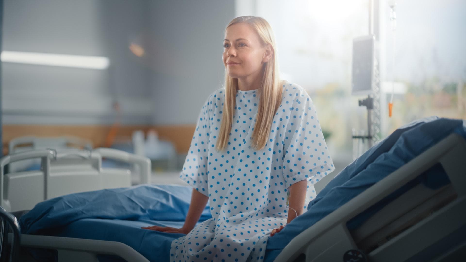 Frau sitzt auf Krankenhausbett Frau sitzt auf Krankenhausbett