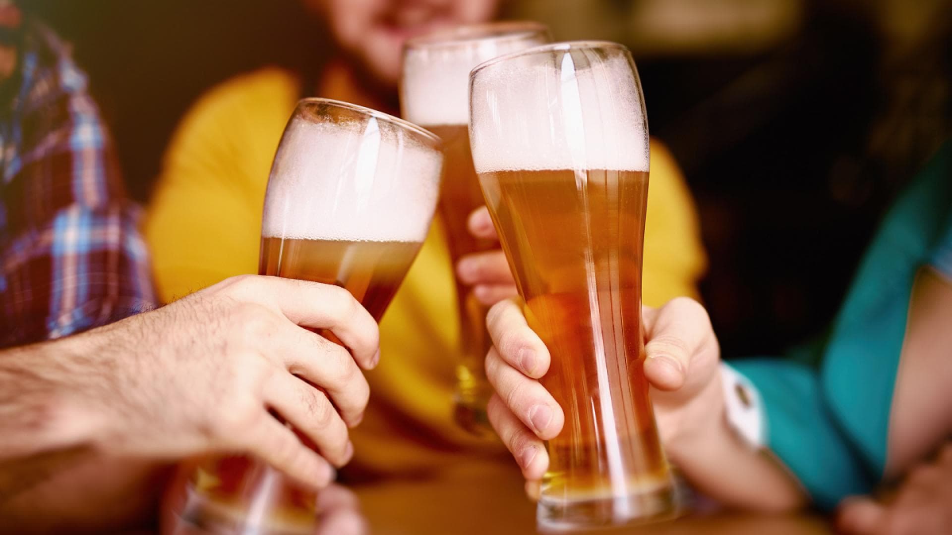 Personen stoßen mit alkoholfreiem Bier an Personen stoßen mit alkoholfreiem Bier an