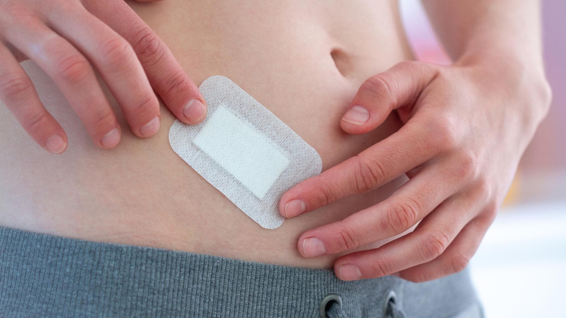 Frau hat ein Pflaster auf dem Bauch kleben Frau hat ein Pflaster auf dem Bauch kleben