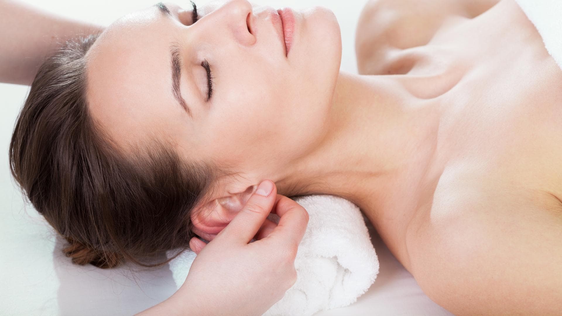 Frau bekommt Ohrmassage Frau bekommt Ohrmassage