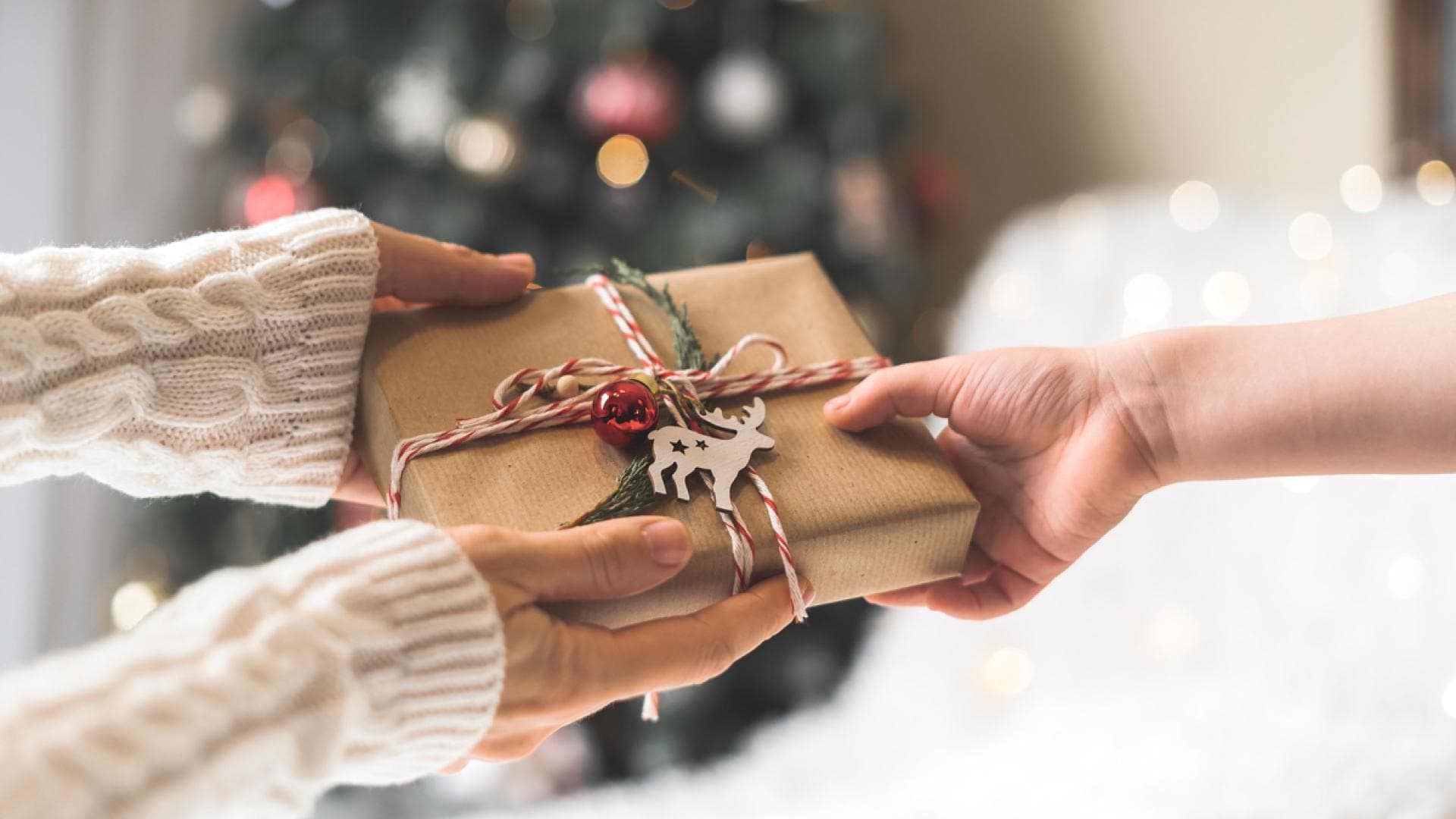Person reicht ein Geschenk Person reicht ein Geschenk