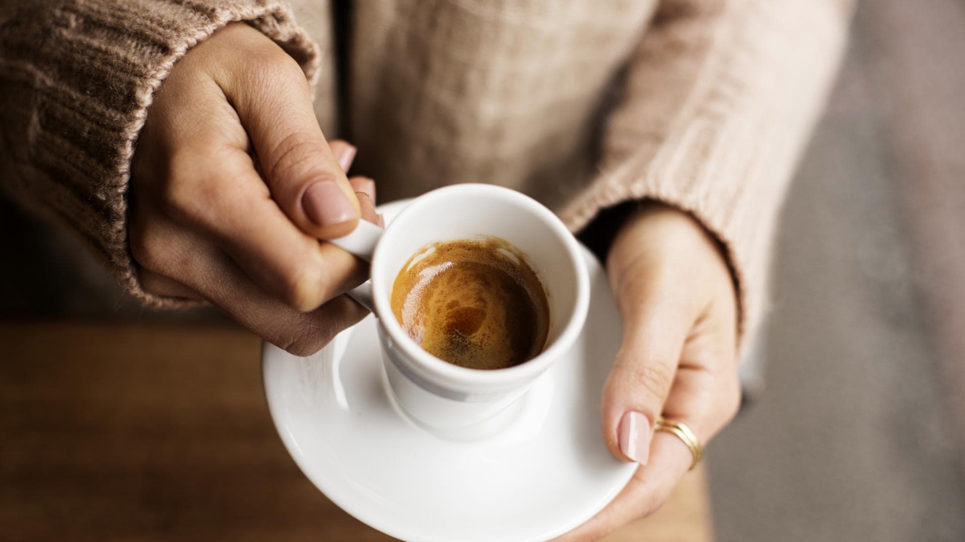 Frau hält Espressotasse in der Hand Frau hält Espressotasse in der Hand