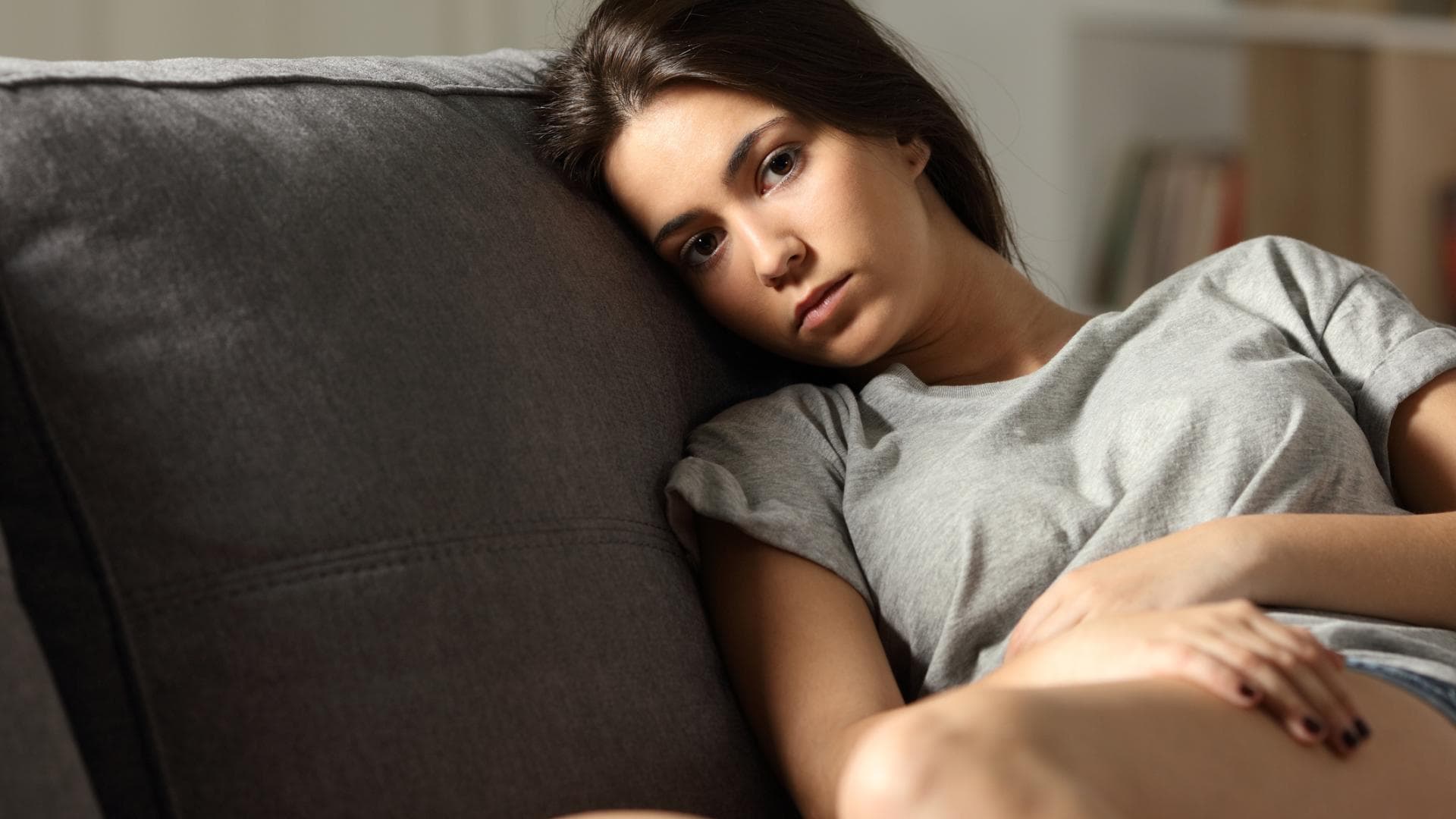 Frau mit depressiven Verstimmungen sitzt auf dem Sofa Frau mit depressiven Verstimmungen sitzt auf dem Sofa