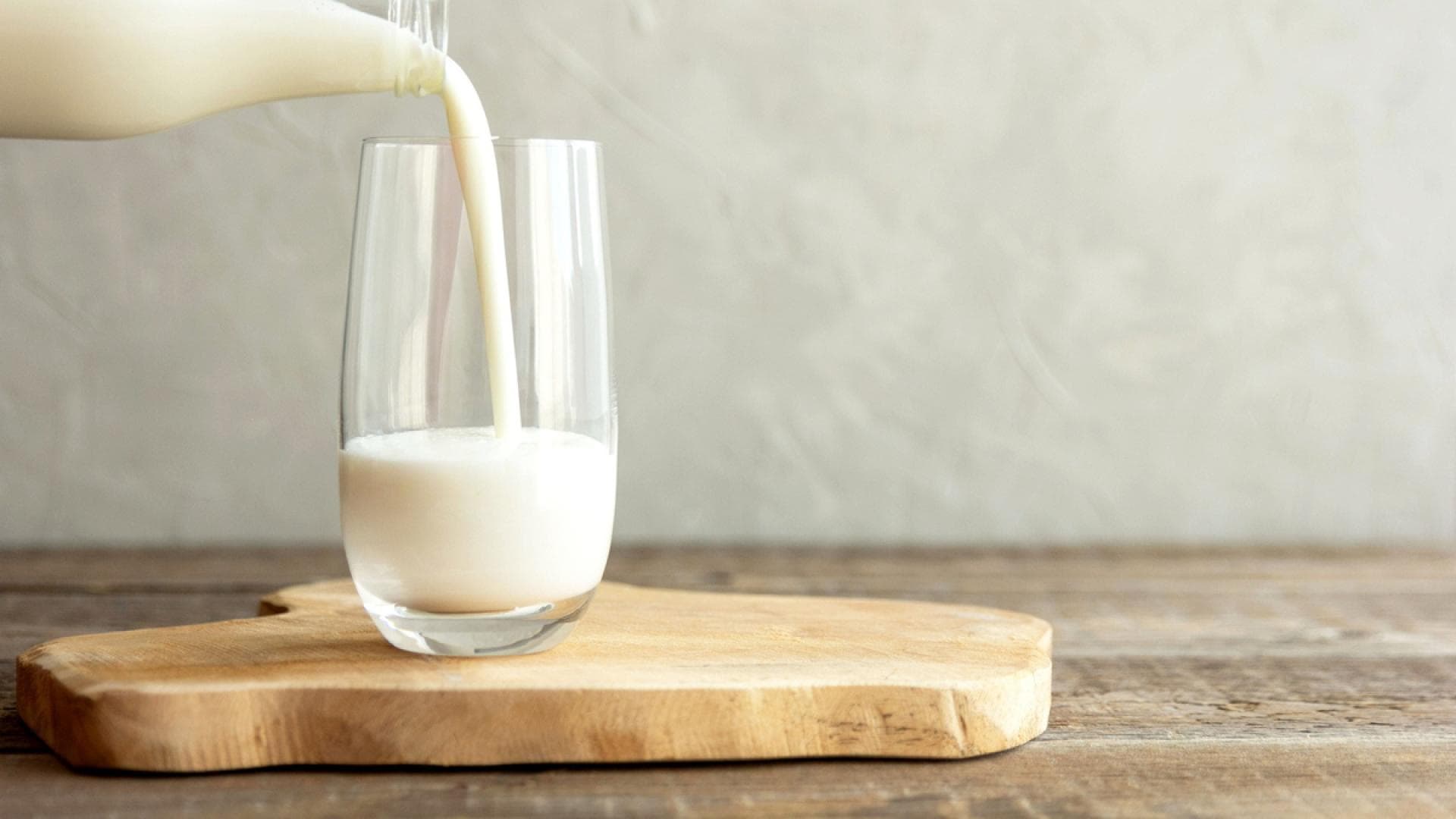 Glas Milch wird eingeschenkt Glas Milch wird eingeschenkt