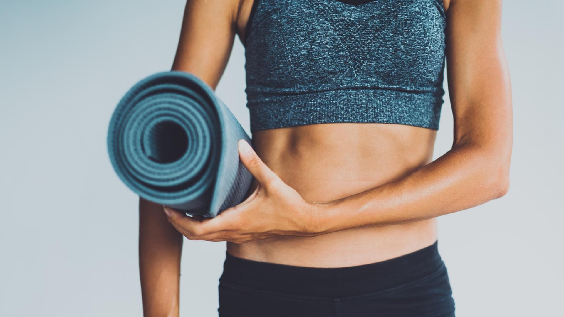 Pilates zielt auf das sogenannte "Powerhouse" ab, also die Körpermitte und trainiert intensiv Bauch- und Rückenmuskulatur. Straffer Bauch einer Frau