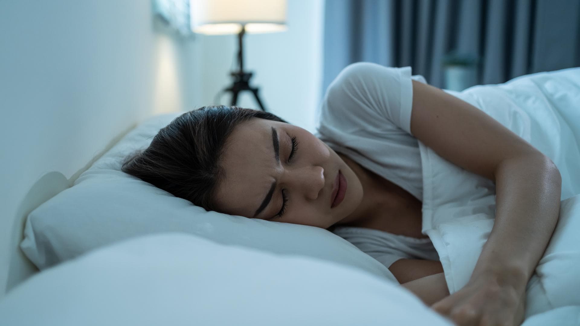 Frau liegt im Bett und träumt schlecht Frau liegt im Bett und träumt schlecht
