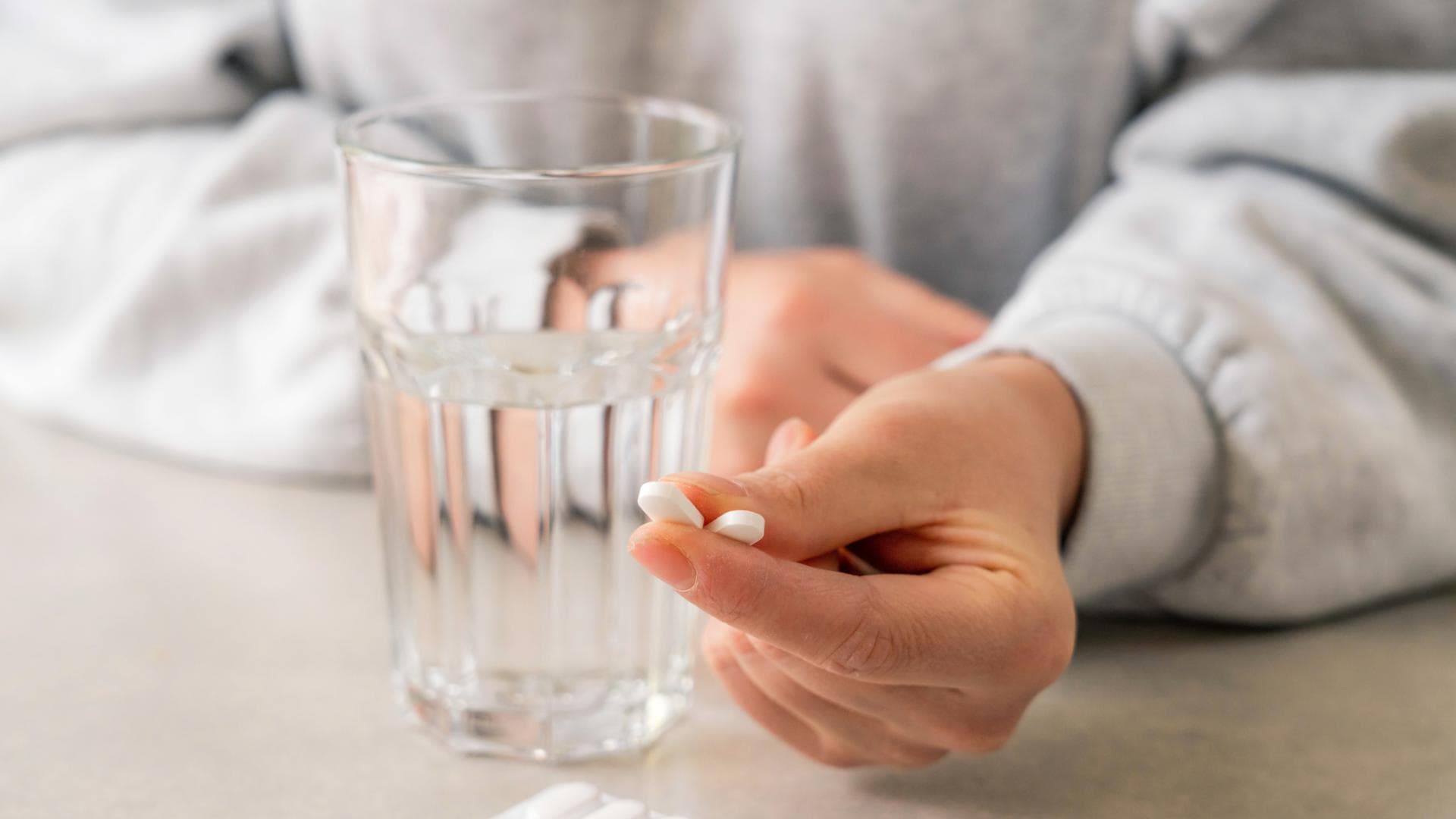 Frau hält zwei Tabletten in den Händen 