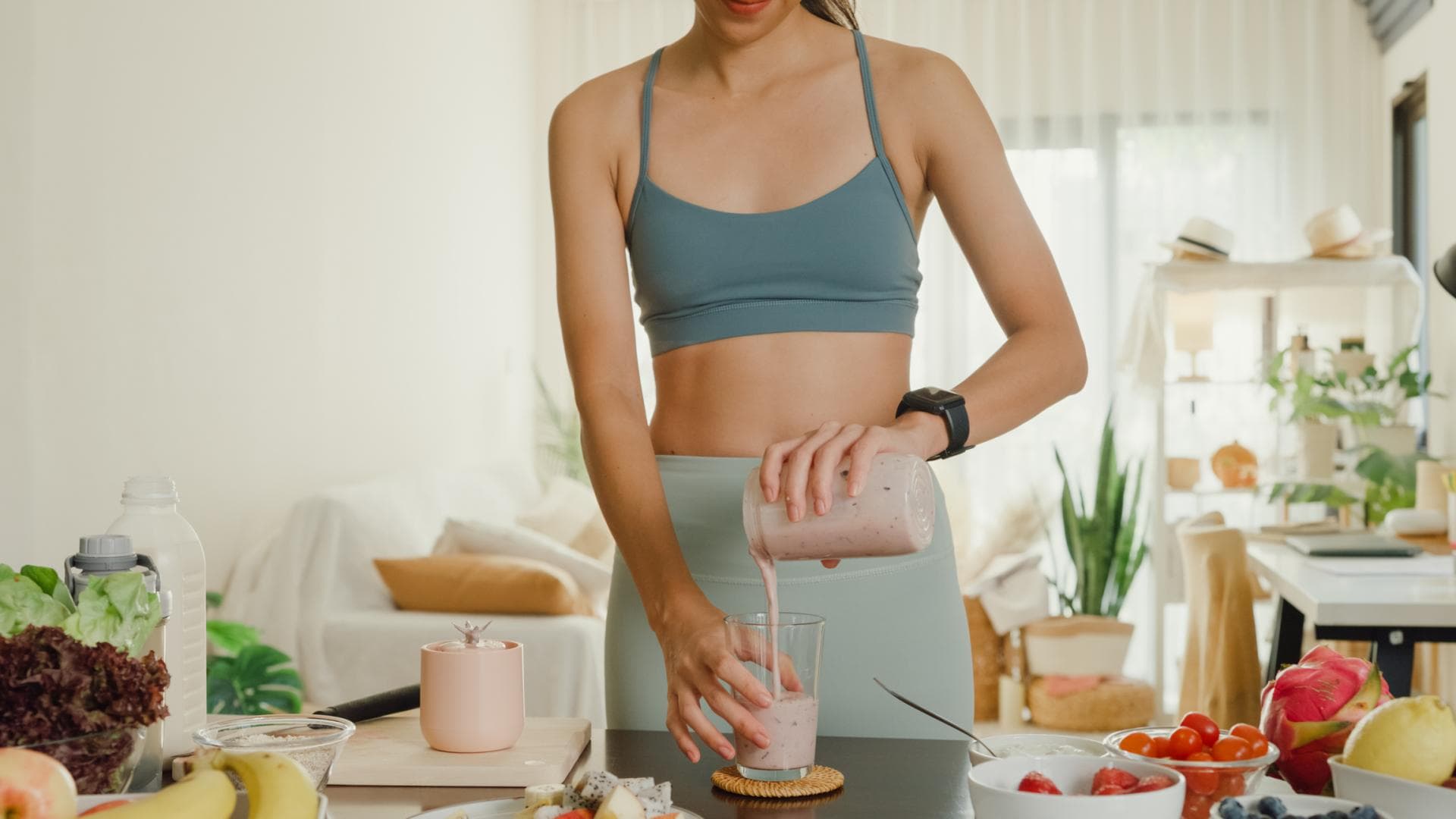 Frau im Sportoutfit macht sich Proteinshake Frau im Sportoutfit macht sich Proteinshake